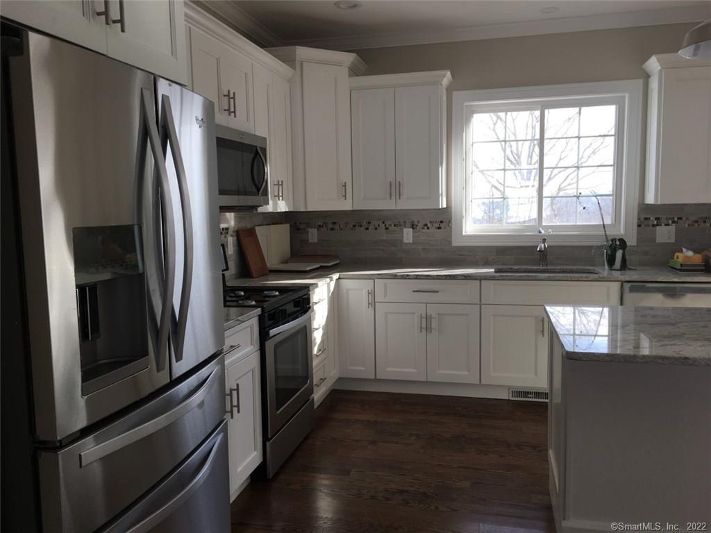 a kitchen with a sink stainless steel appliances and window
