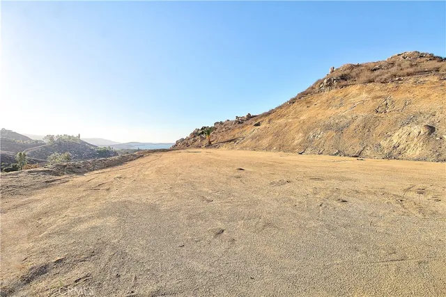 a view of a large yard with mountains in the background