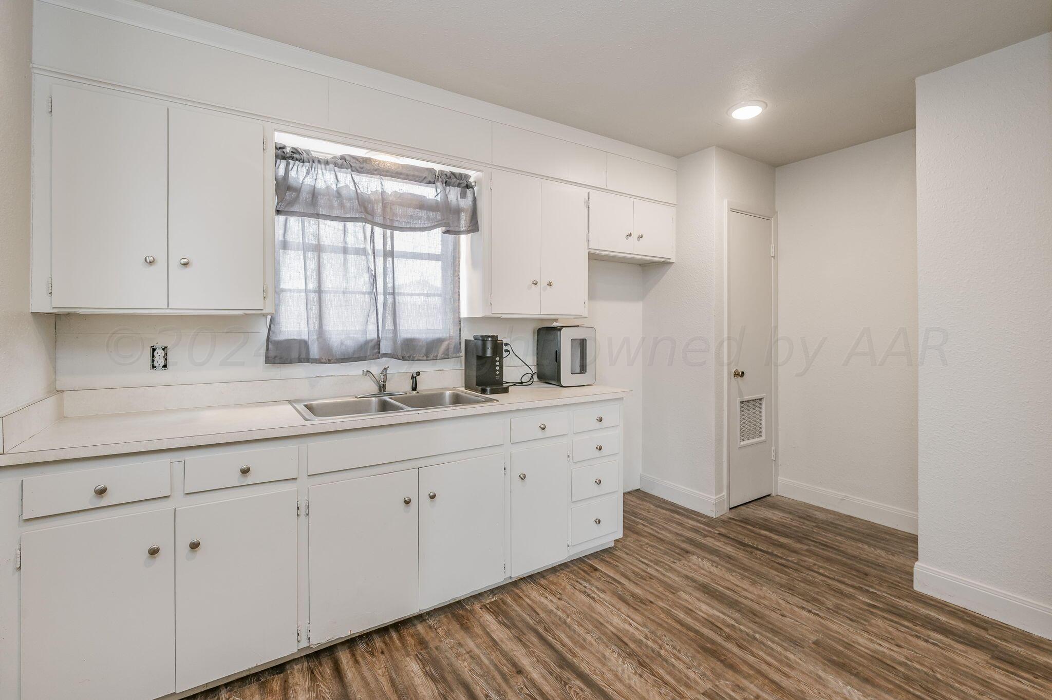 4205 South Bonham Street Amarillo, TX 79110 - Photo 23 of 24 a kitchen with white cabinets and wooden floor