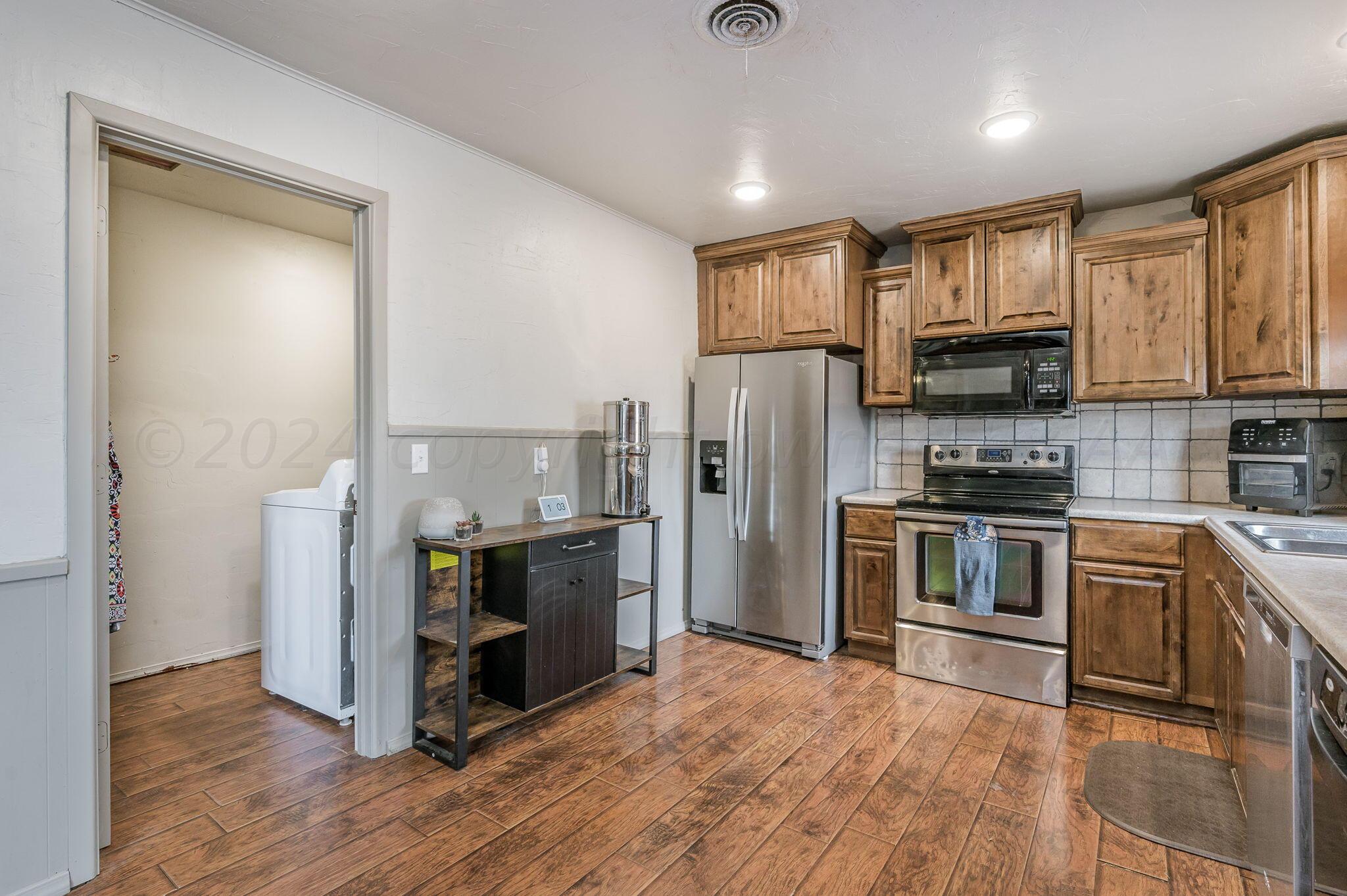4205 South Bonham Street Amarillo, TX 79110 - Photo 8 of 24 a kitchen with granite countertop a refrigerator and a stove top oven