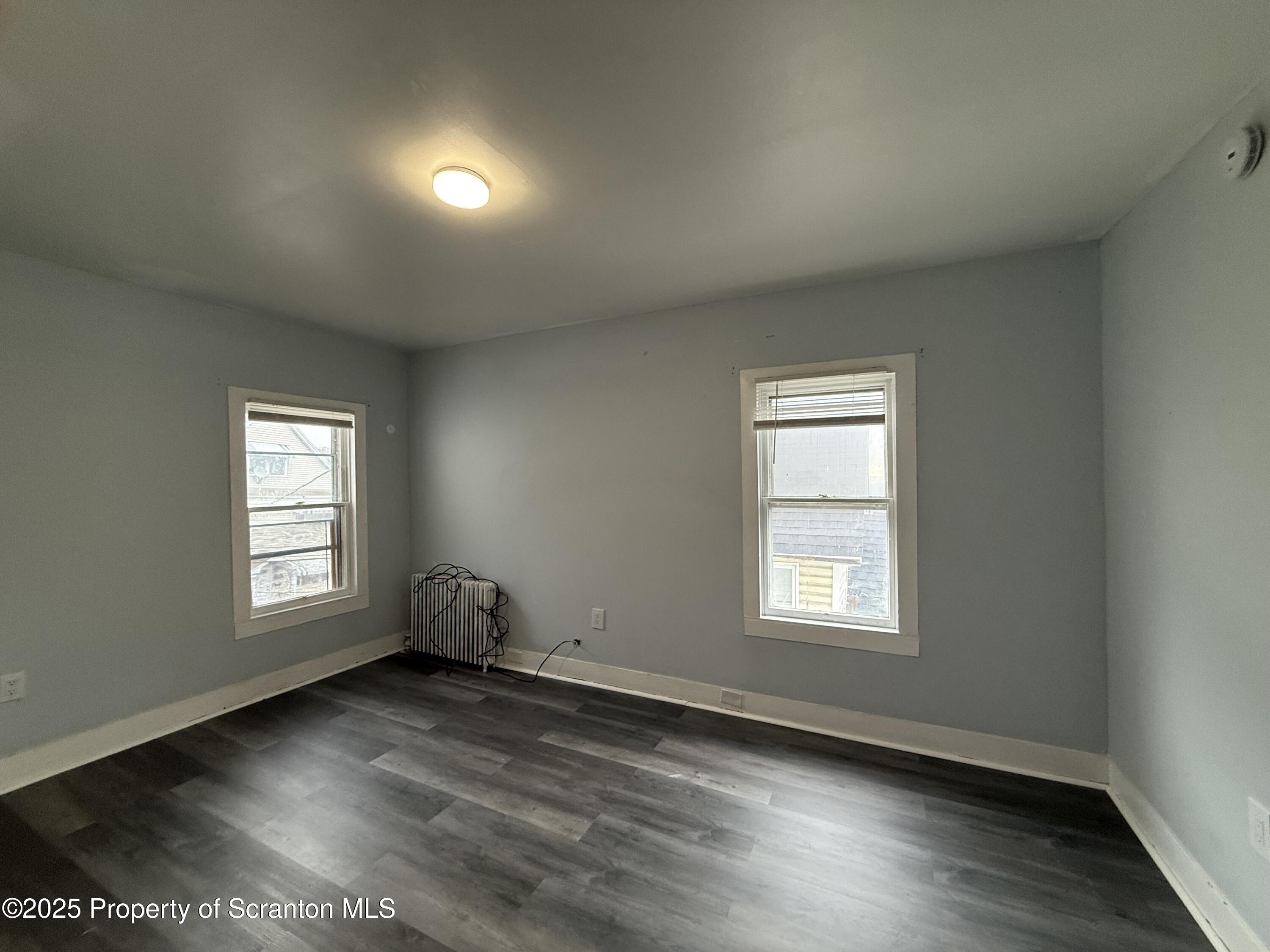 203 Greenbush Street Scranton, PA 18508 - Photo 17 of 20 an empty room with wooden floor and windows