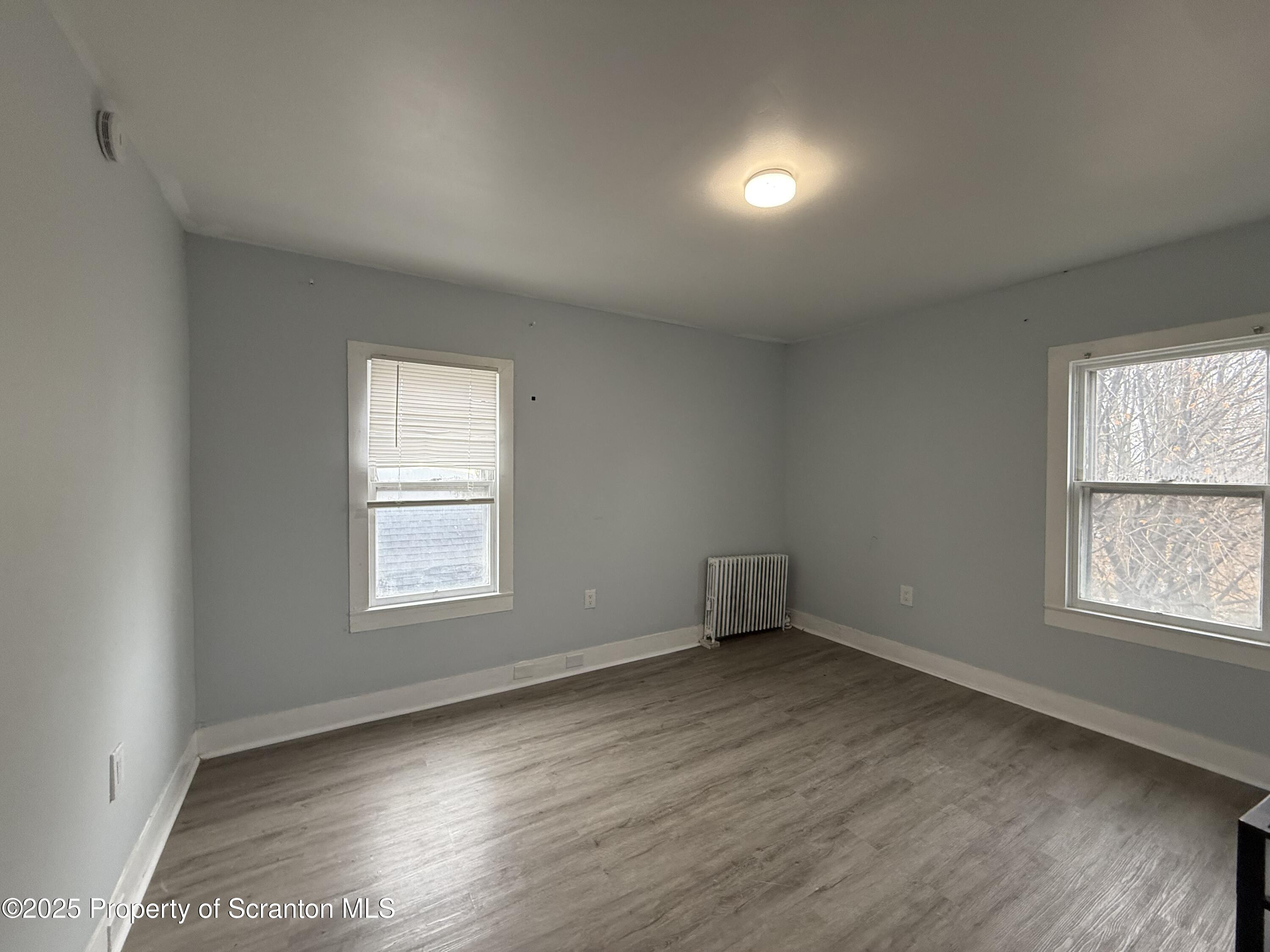 203 Greenbush Street Scranton, PA 18508 - Photo 18 of 20 an empty room with wooden floor and windows