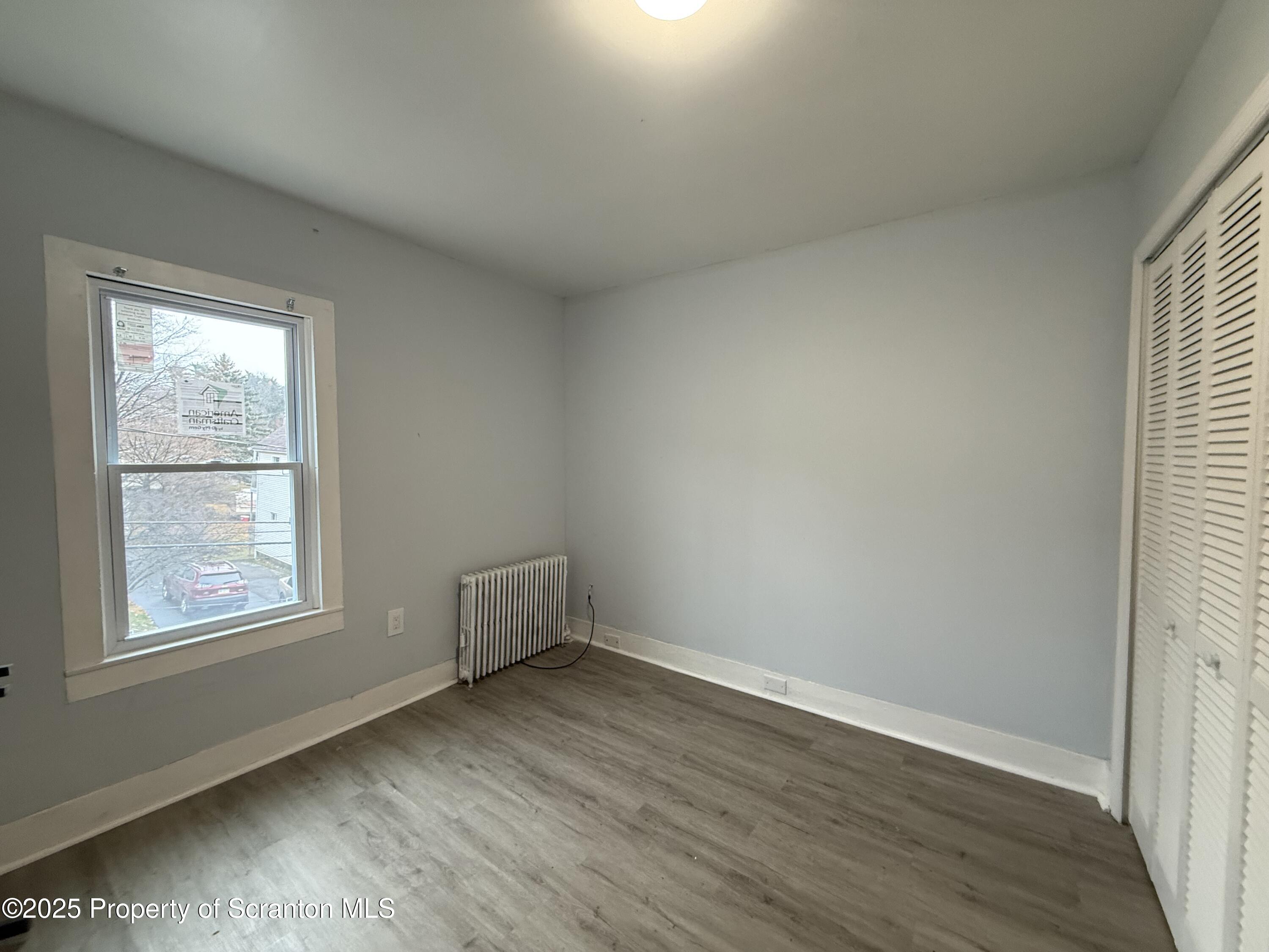 203 Greenbush Street Scranton, PA 18508 - Photo 19 of 20 an empty room with wooden floor and windows