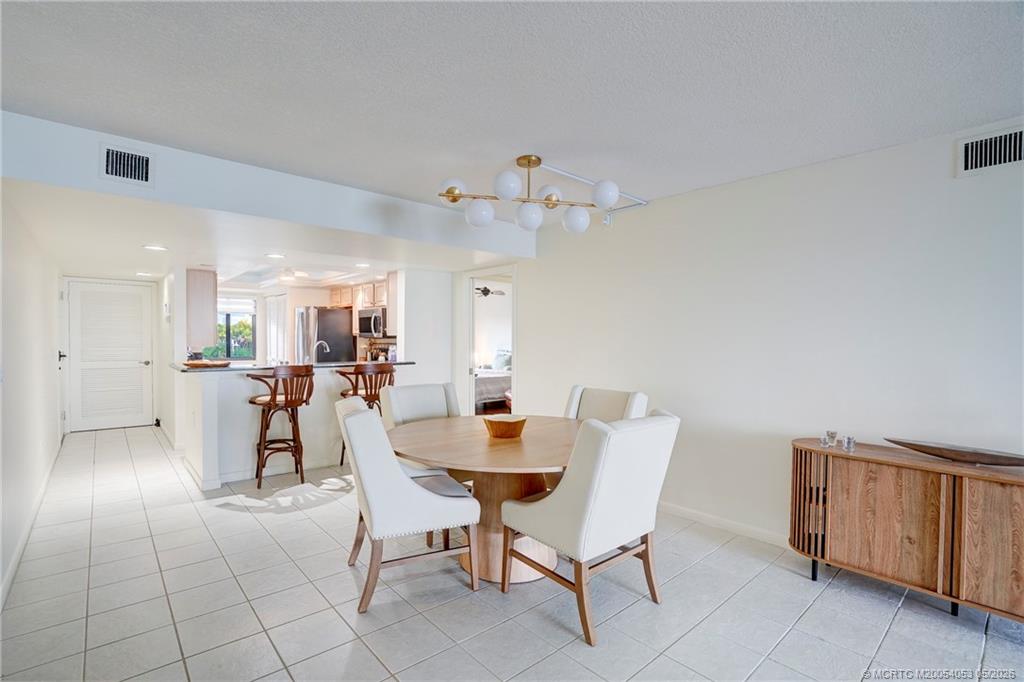 10 Northeast Plantation Road, Unit 101 Jensen Beach, FL 34957 - Photo 11 of 53 a dining room with furniture and a chandelier