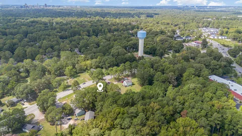 an aerial view of residential house with outdoor space and trees all around