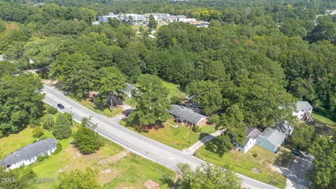 an aerial view of residential house with outdoor space and trees all around