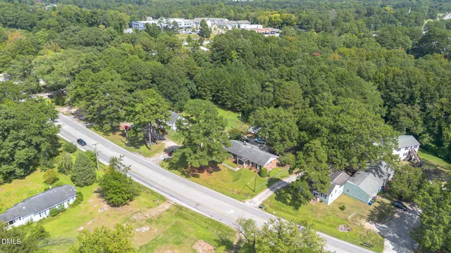 an aerial view of residential house with outdoor space and trees all around