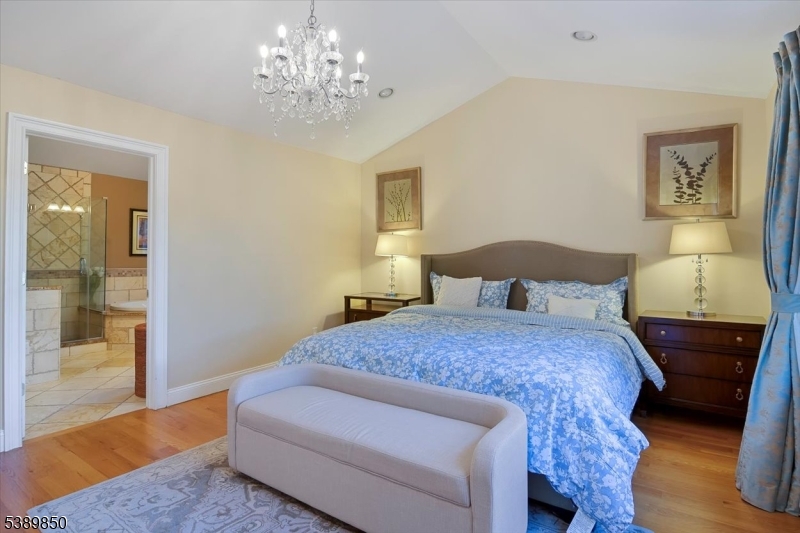 68 Horseneck Road Montville, NJ 07045 - Photo 15 of 34 a bedroom with a bed and a chandelier