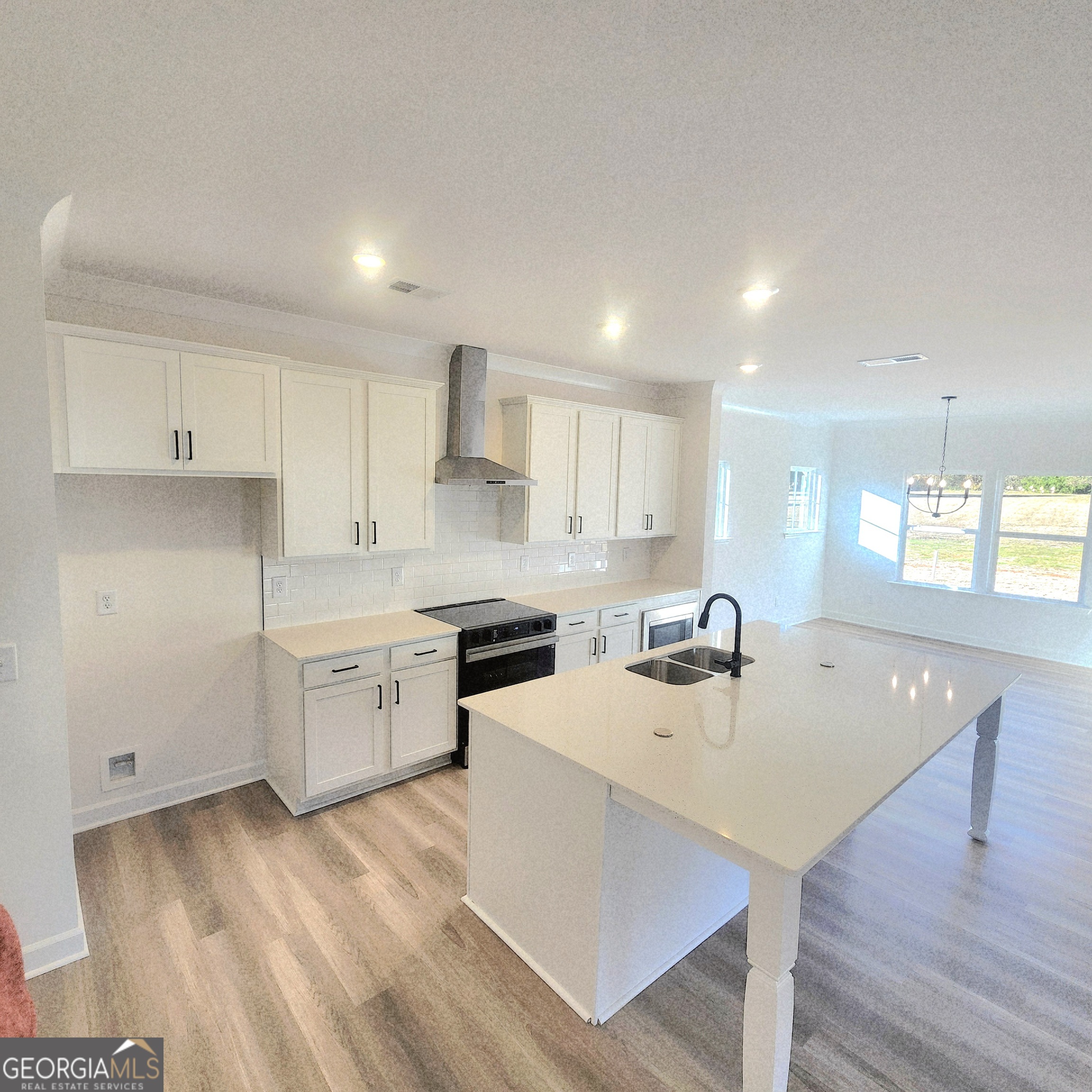 431 North Unity Grove Road Locust Grove, GA 30248 - Photo 5 of 18 a kitchen with a sink a stove a refrigerator and white cabinets