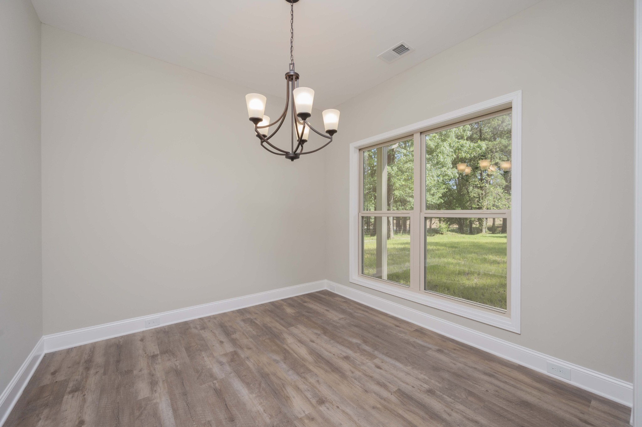 283 Providence Road Pelham, TN 37366 - Photo 4 of 24 a view of an empty room with wooden floor and a window