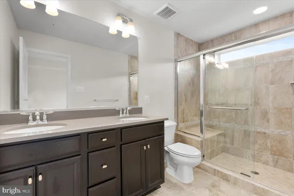 a bathroom with a double vanity sink toilet and shower