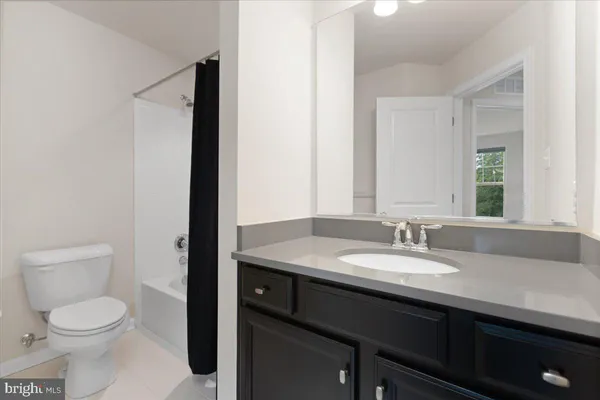 a bathroom with a granite countertop sink toilet and mirror
