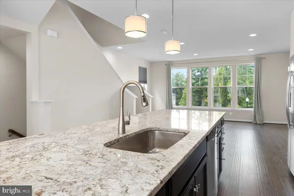 a kitchen with a sink a counter top space and a wooden floor