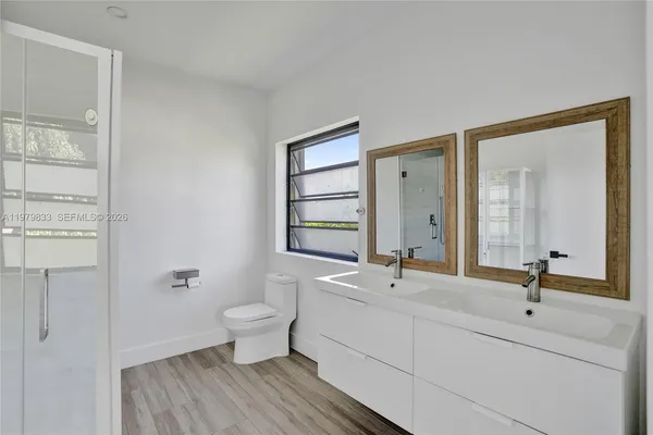 a bathroom with a double vanity sink toilet and a mirror