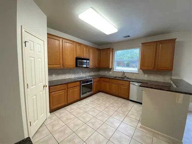 a kitchen with stainless steel appliances granite countertop a refrigerator sink and cabinets