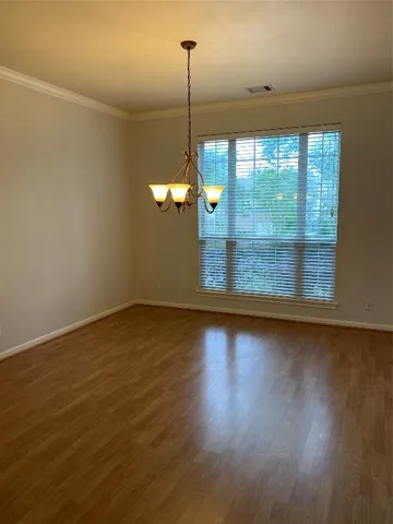 a view of a room with wooden floor and a window