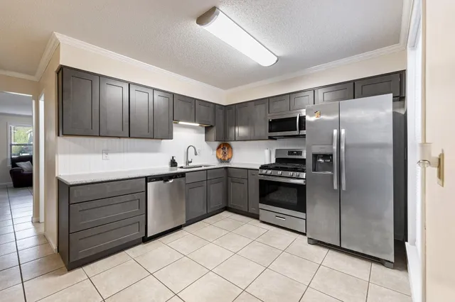 a kitchen with a refrigerator sink and cabinets