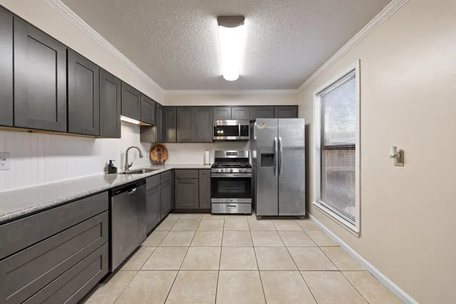a kitchen with granite countertop a refrigerator and a sink