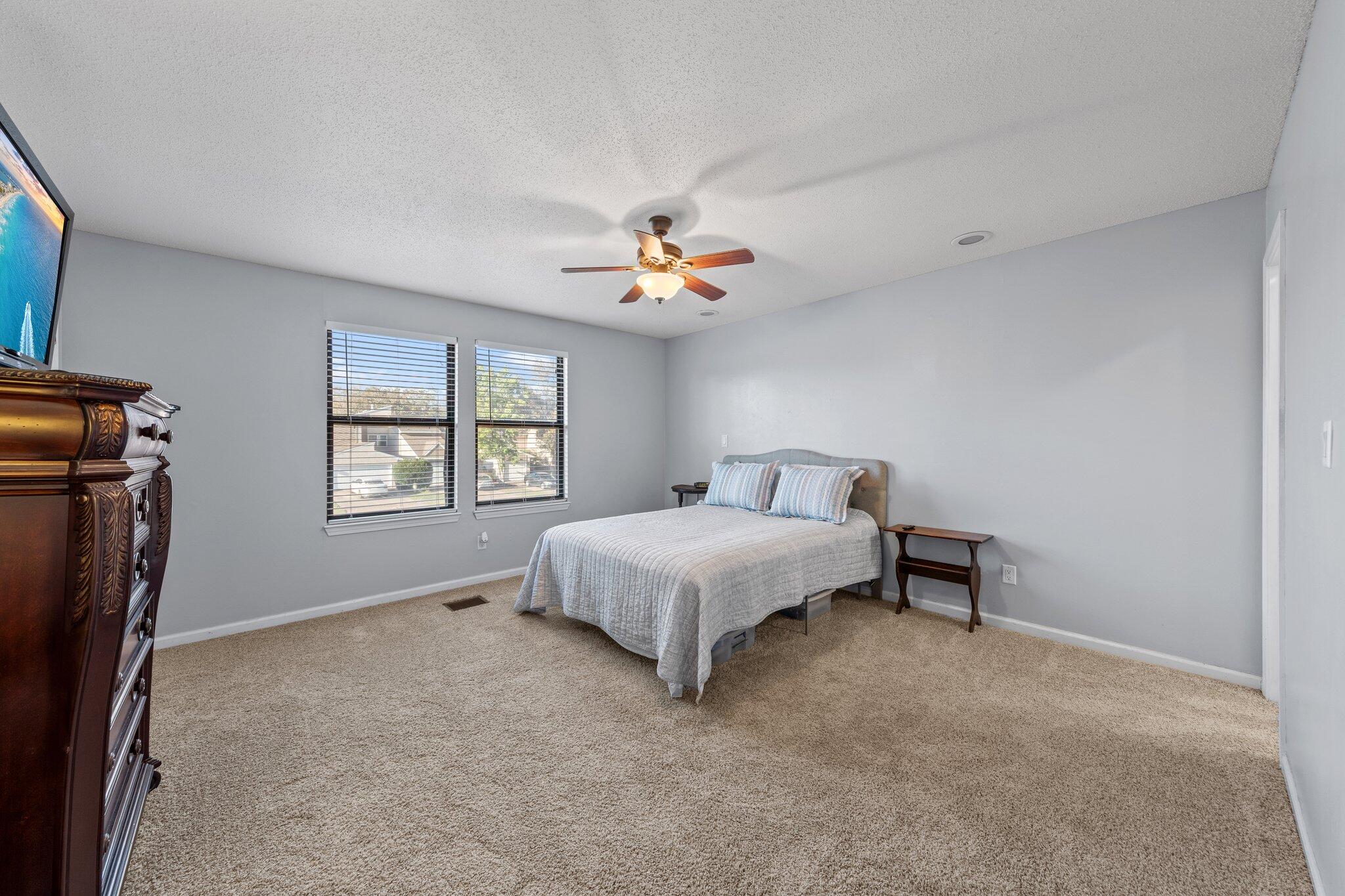 114 4th Avenue Shalimar, FL 32579 - Photo 26 of 59 a spacious bedroom with a bed and a chandelier