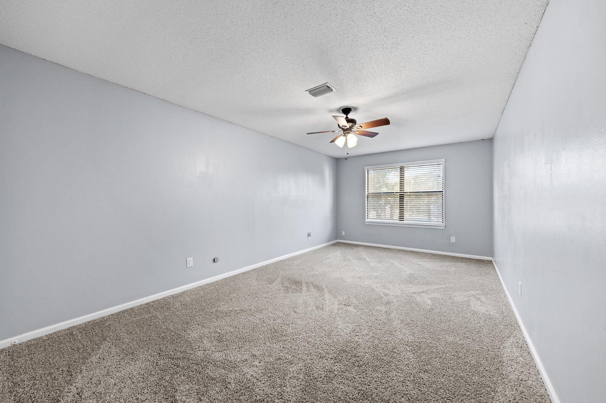 114 4th Avenue Shalimar, FL 32579 - Photo 39 of 59 an empty room with chandelier fan and windows