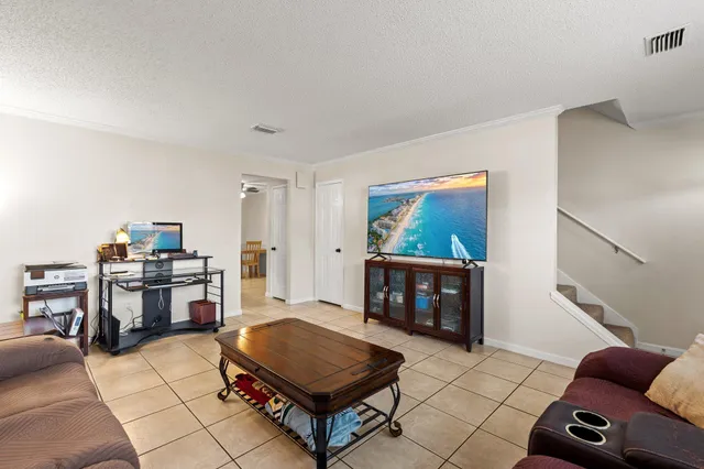 a living room with furniture a flat screen tv and a stove