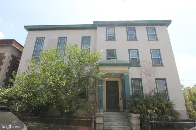 a front view of a house with plants