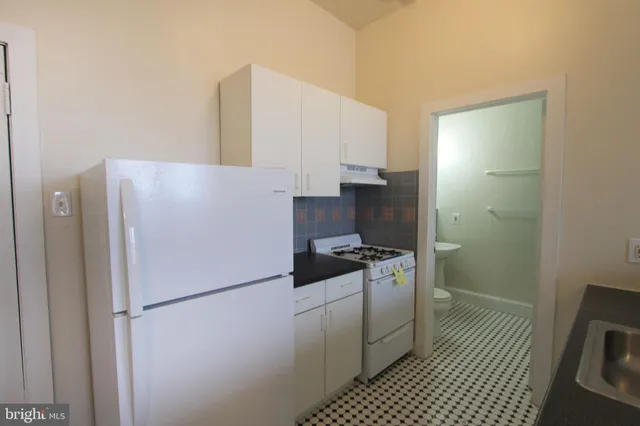 a white refrigerator freezer and a stove sitting inside of a kitchen
