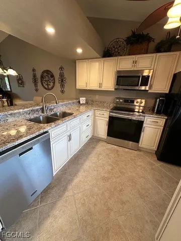 a large kitchen with stainless steel appliances granite countertop a sink and cabinets