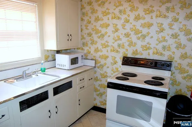 a kitchen with a stove and white cabinets