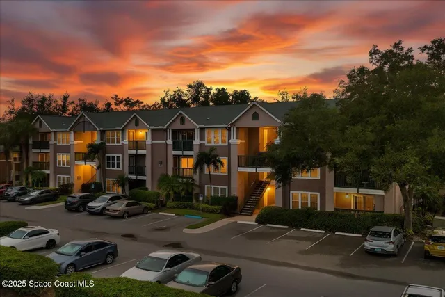 a front view of a house with cars parked on the roadside