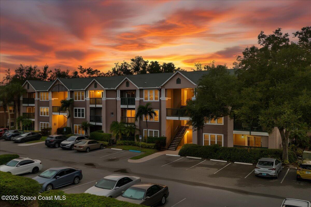 a front view of a house with cars parked on the roadside