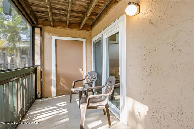 a patio with table and chairs and potted plants
