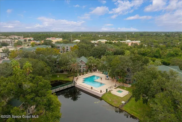 an aerial view of residential houses with outdoor space and trees