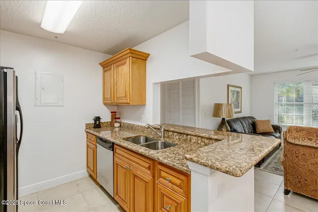 a kitchen with granite countertop a sink and a refrigerator