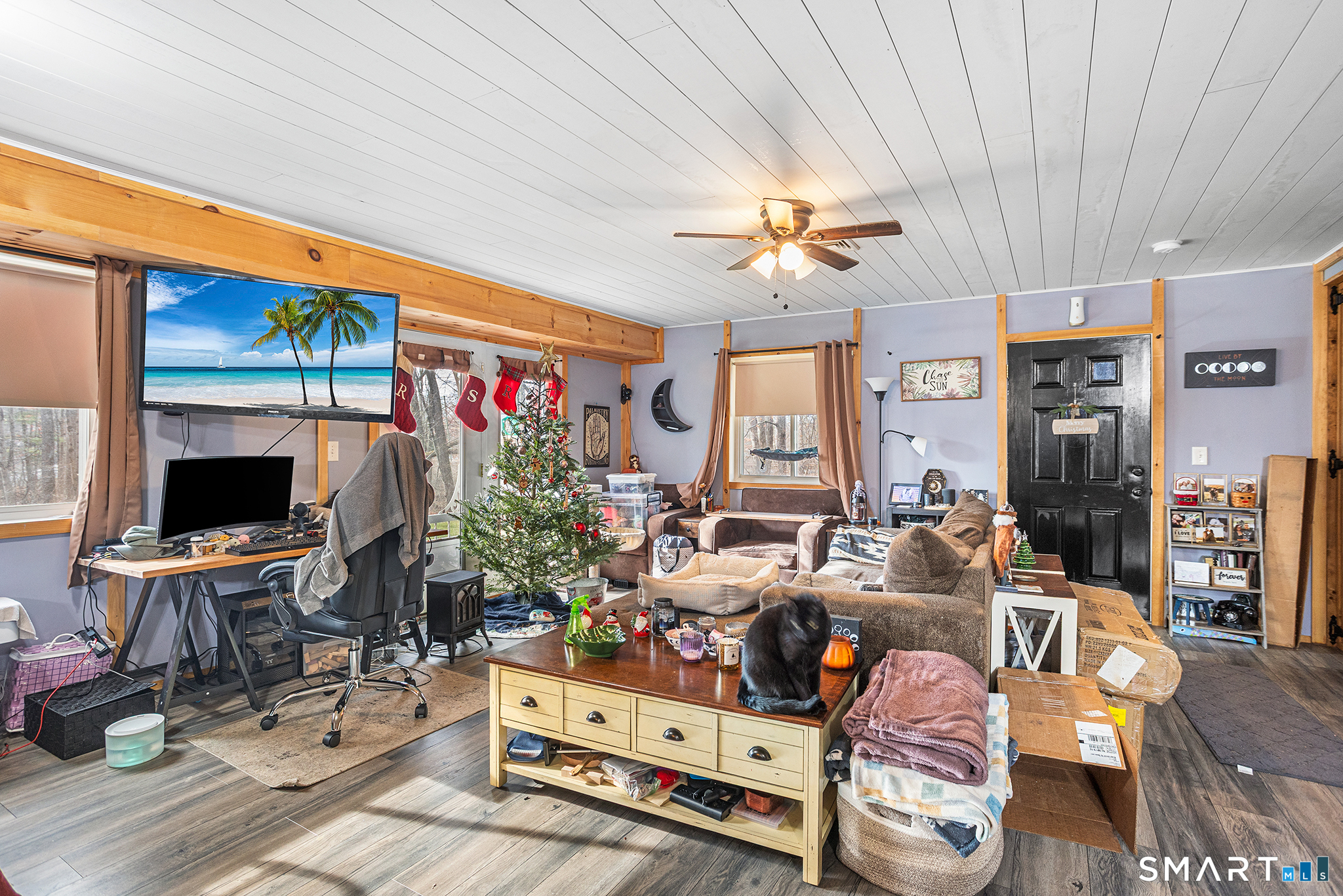 600 Woodtick Road Wolcott, CT 06716 - Photo 16 of 28 a living room with furniture a flat screen tv and a floor to ceiling window