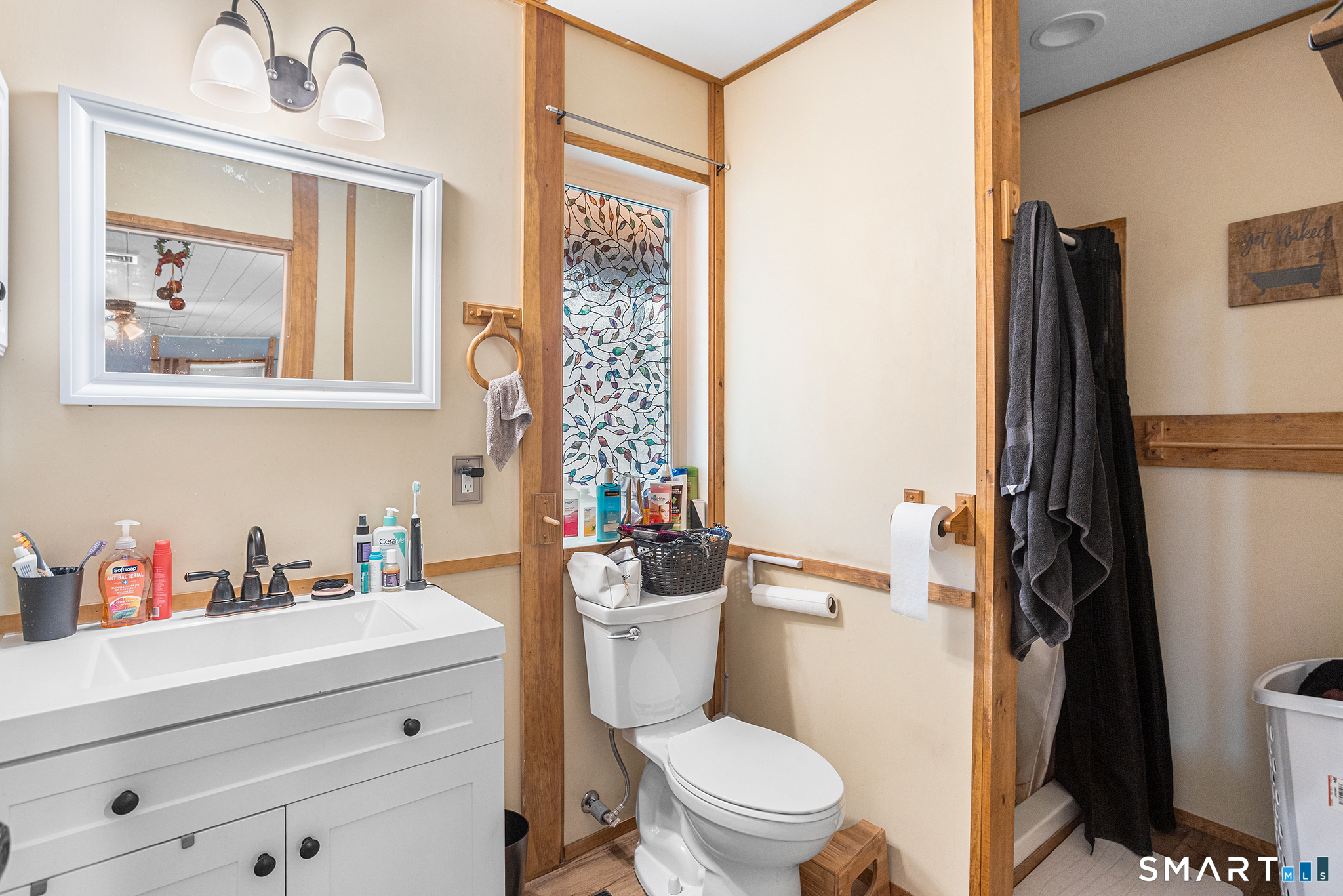 600 Woodtick Road Wolcott, CT 06716 - Photo 20 of 28 a bathroom with a sink a toilet a mirror and shower curtain
