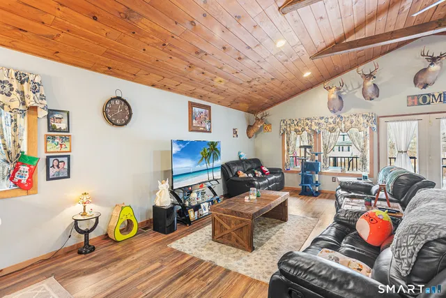 a living room with furniture wooden floor and wall painting