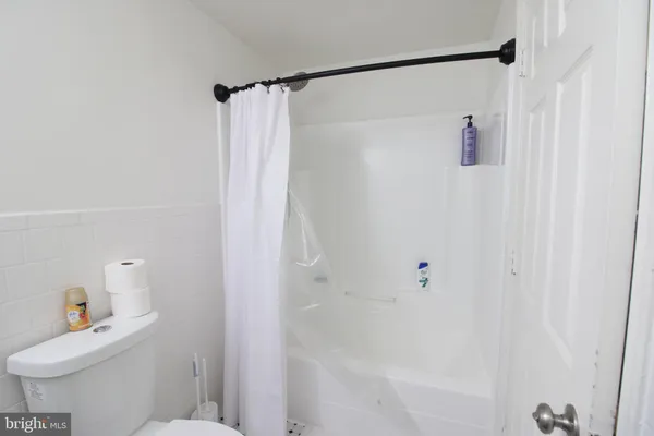 a white toilet sitting next to a bath tub