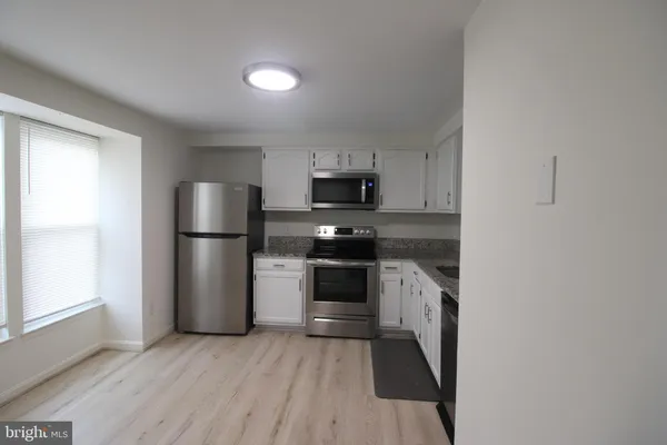 a kitchen with a refrigerator and a stove top oven