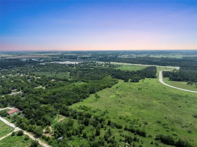 a view of a green field with lots of bushes