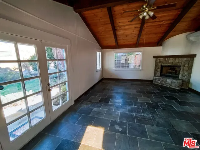 a view of empty room with wooden floor and fireplace
