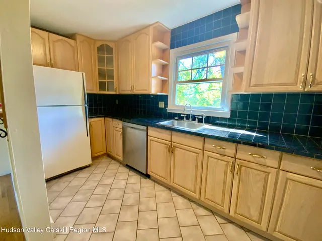 a kitchen with stainless steel appliances a sink window and cabinets