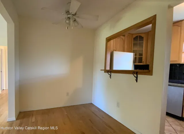 a view of a hallway with wooden floor and a cabinet