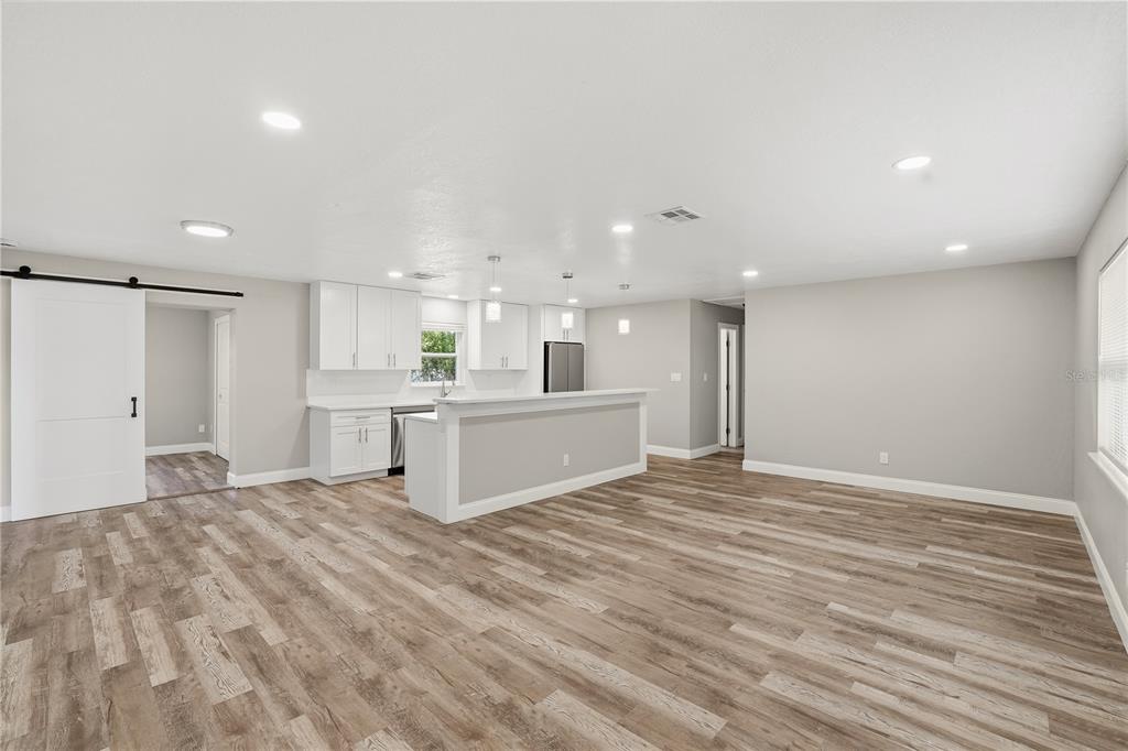 11525 81st Place Seminole, FL 33772 - Photo 11 of 24 a view of a kitchen with kitchen island a sink dishwasher and a refrigerator with wooden floor
