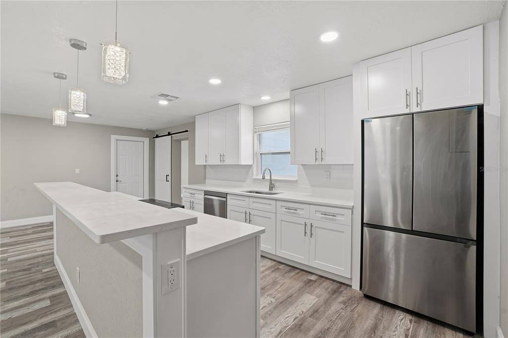 11525 81st Place Seminole, FL 33772 - Photo 15 of 24 a kitchen with white cabinets a refrigerator and a stove