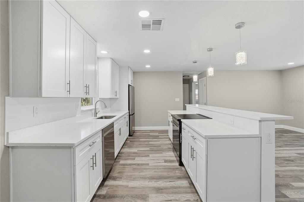 11525 81st Place Seminole, FL 33772 - Photo 16 of 24 a kitchen with a sink a stove top oven a counter space and cabinets