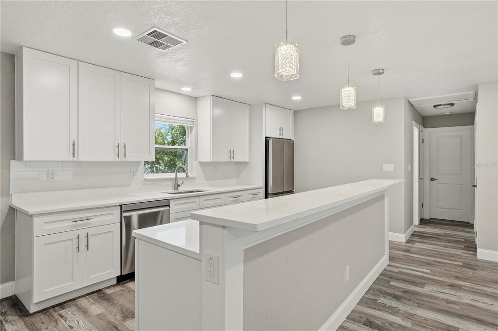 11525 81st Place Seminole, FL 33772 - Photo 17 of 24 a kitchen with a sink a counter top space stainless steel appliances and cabinets