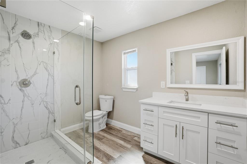11525 81st Place Seminole, FL 33772 - Photo 21 of 24 a bathroom with a granite countertop sink a toilet and shower