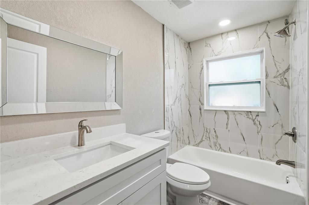 11525 81st Place Seminole, FL 33772 - Photo 8 of 24 a bathroom with a sink a toilet and shower