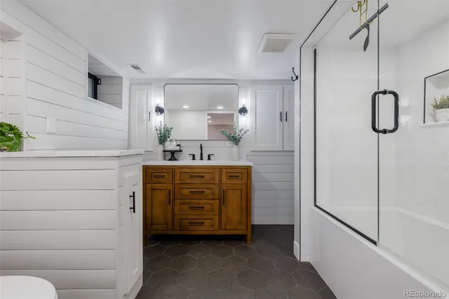 a bathroom with a shower sink and mirror